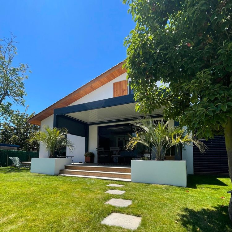 Vue extérieure de la villa neuve située en bout d’impasse à Anglet, montrant son design moderne et naturel, contrastant avec l’environnement urbain.