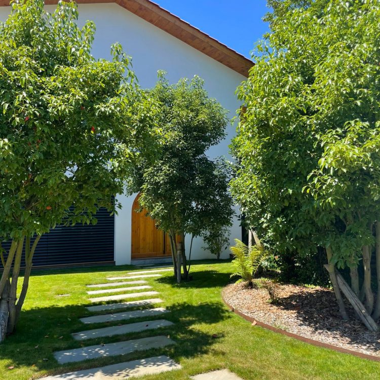 Photographie de la façade avant de la villa neuve, mettant en valeur l'architecture unique et les matériaux utilisés