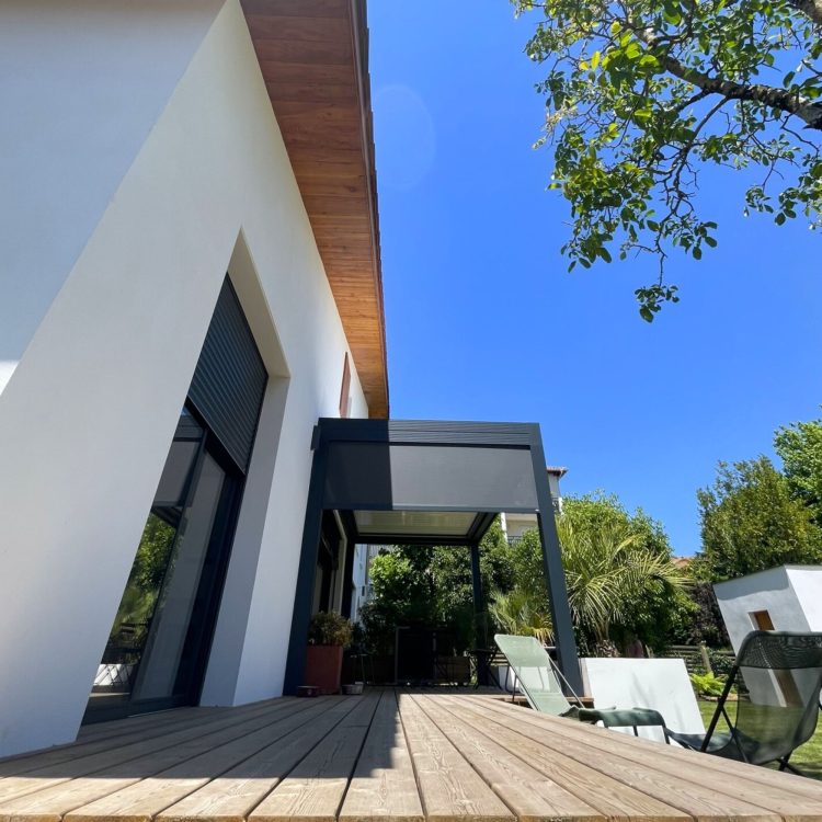 Vue de la pergola extérieure attenante à la villa neuve, offrant un espace de détente ombragé et esthétique.