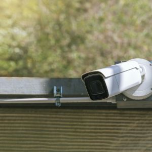 Système de sécurité connecté surveillant une maison moderne avec alarme et caméras.